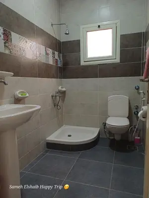 a bathroom with a toilet and a sink and a window at Suncare America Resort - luxury rooms in Hurghada