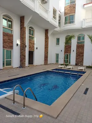 a swimming pool in front of a building at Suncare America Resort - luxury rooms in Hurghada