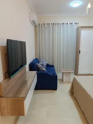 a living room with a blue couch and a flat screen tv at Hurghada Sea view with pool in Hurghada