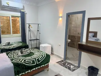a room with two beds and a bathroom with a shower at Aswan City Star in Aswan