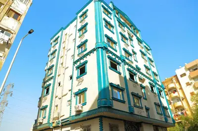 a tall blue and white building on a street at Aswan City Star in Aswan