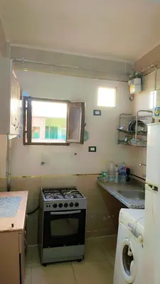 a small kitchen with a stove and a window at Atlas Aswan Apartment Near Nile Corniche and Old Tourist Market شقة أطلس أسوان بجوار كورنيش النيل والسوق السياحي القديم in Aswan