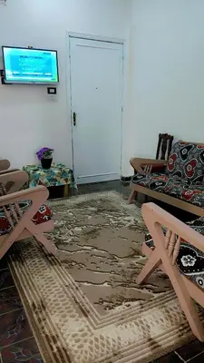 a living room with a couch and a table and a tv at Atlas Aswan Apartment Near Nile Corniche and Old Tourist Market شقة أطلس أسوان بجوار كورنيش النيل والسوق السياحي القديم in Aswan