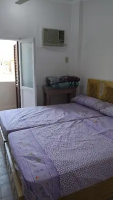 a bedroom with a purple comforter on a bed at Atlas Aswan Apartment Near Nile Corniche and Old Tourist Market شقة أطلس أسوان بجوار كورنيش النيل والسوق السياحي القديم in Aswan