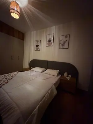 a bedroom with a large white bed and a light at Magawish resort in Hurghada