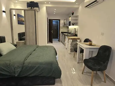 a bedroom with a bed and a table and a kitchen at El Hambra Compound in Hurghada