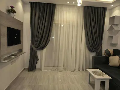 a living room with a couch and a window with curtains at El Hambra Compound in Hurghada