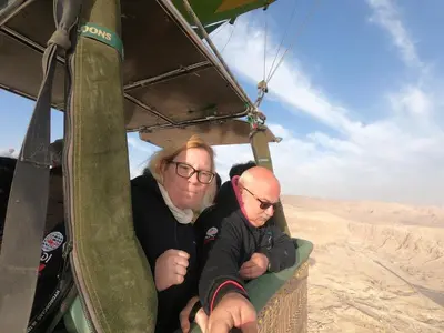 two people sitting in the back of a helicopter at Luxor Adventure Guest House in Al Aqālitah