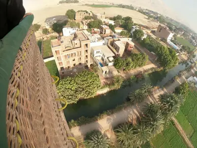 an aerial view of a large house on a river at Luxor Adventure Guest House in Al Aqālitah