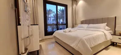 a bedroom with a white bed with a window at El Gouna Luxury 1BR Golf Apartment at Ancient Sands Resort Pool, Beach & Marina Access in Hurghada
