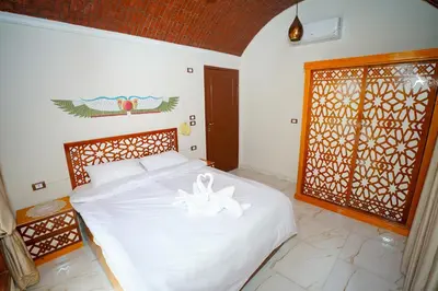 a bedroom with a white bed and a window at Osman House Luxor in Luxor