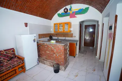 a kitchen with a brick counter and a refrigerator at Osman House Luxor in Luxor