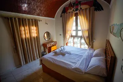a bedroom with a bed and a large window at Osman House Luxor in Luxor