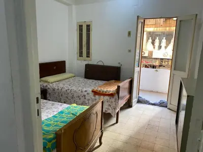 a small bedroom with two beds and a doorway at Nile Cruise Aswan in Luxor