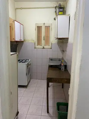 a small kitchen with a table and a stove at Nile Cruise Aswan in Luxor