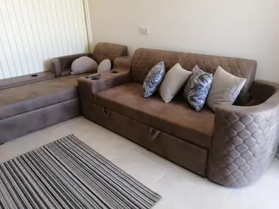a brown couch with pillows on it in a living room at Tiba Golden Resort in Hurghada