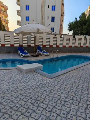 a swimming pool with two chairs and an umbrella at THE BESt in Hurghada