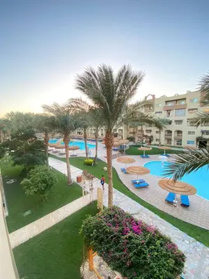 an aerial view of a resort with a pool and palm trees at alkarma nubia apartment 1521 in Hurghada