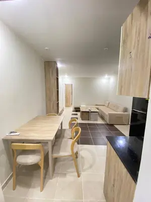 a kitchen and living room with a table and a couch at alkarma nubia apartment 1521 in Hurghada