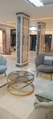 a lobby with a glass coffee table and chairs at فندق ميريت امون سوهاج in Jazīrat Maḩrūs