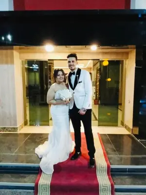 a bride and groom posing for a picture on a red carpet at فندق ميريت امون سوهاج in Jazīrat Maḩrūs