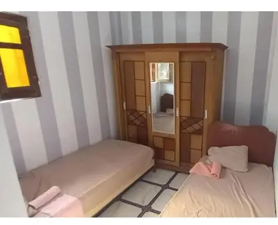 a small room with two beds and a cabinet at Safy Guest House in Aswan