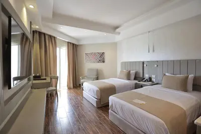 a hotel room with two beds and a desk at Xanadu Club Makadi Bay - High Class All Inclusive in Hurghada