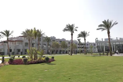 a park in front of a building with palm trees at Xanadu Club Makadi Bay - High Class All Inclusive in Hurghada