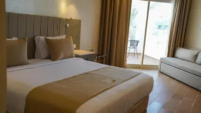 a hotel room with a large bed and a couch at Xanadu Club Makadi Bay - High Class All Inclusive in Hurghada