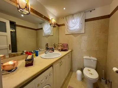 a bathroom with a sink and a toilet and a mirror at Lagoon Charm | 1BR in Steigenberger El Gouna in Hurghada