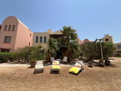 a group of chaise lounges and chairs in a yard at Lagoon Charm | 1BR in Steigenberger El Gouna in Hurghada