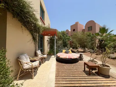 a patio with chairs and a bed on a deck at Lagoon Charm | 1BR in Steigenberger El Gouna in Hurghada