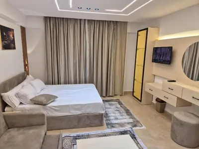 a bedroom with a bed and a tv and a couch at Bay View Sahl Hasheesh Chalet in Hurghada