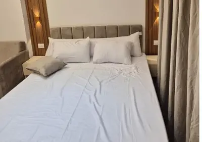 a large bed with white sheets and pillows at Bay View Sahl Hasheesh Chalet in Hurghada