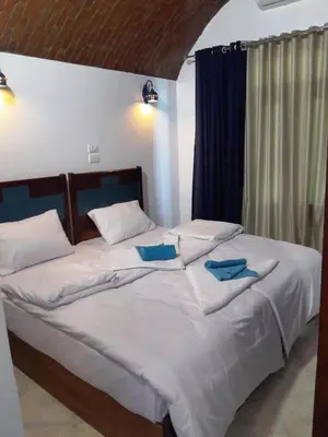 a bedroom with two beds with blue pillows on them at Nubian Spirit in Aswân Reservoir Colony