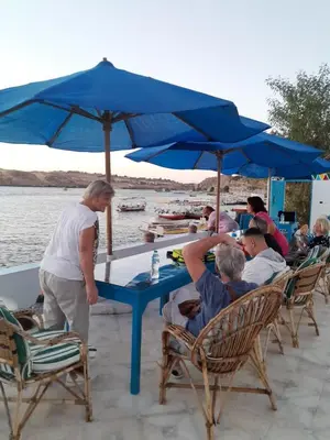 a group of people sitting at a table under an umbrella at Nubian Spirit in Aswân Reservoir Colony