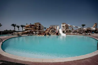 a large pool with a water slide in a resort at Nubia Beach Resort in Hurghada