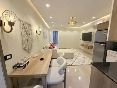 a kitchen and living room with a table and a couch at Nubia Beach Resort in Hurghada