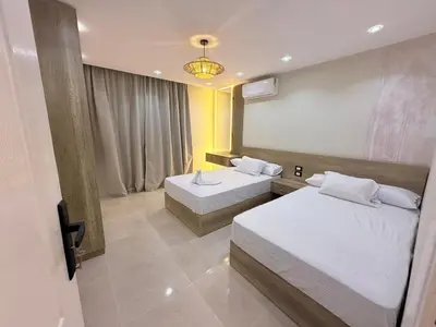 a hotel room with two beds and a chandelier at Nubia Beach Resort in Hurghada