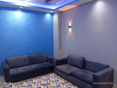 a living room with a couch and a blue wall at Red Ruby chalets & flats HRG Elgouna in Hurghada