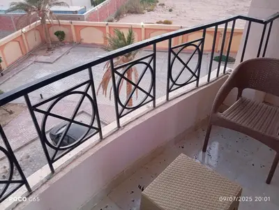a balcony with a bench and a chair at Red Ruby chalets & flats HRG Elgouna in Hurghada