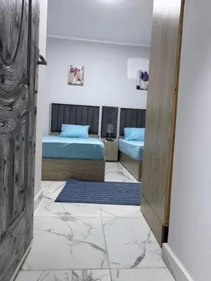 a room with two beds and a door to a bedroom at Inter Prime apartment 4 in Hurghada