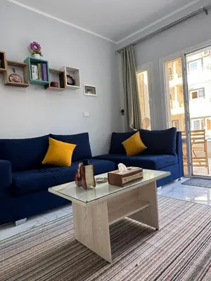a living room with a blue couch and a coffee table at Inter Prime apartment 4 in Hurghada