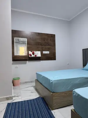 a bedroom with two beds and a sign on the wall at Inter Prime apartment 4 in Hurghada
