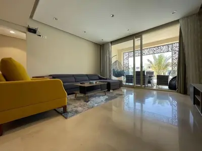 a living room with a yellow couch and a table at Mangroovy - 2Br Commodious Pool&Gouna views Condo in Hurghada