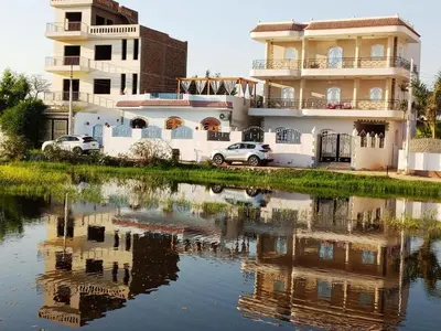 a house with a reflection in a body of water at family villa private pool in Luxor