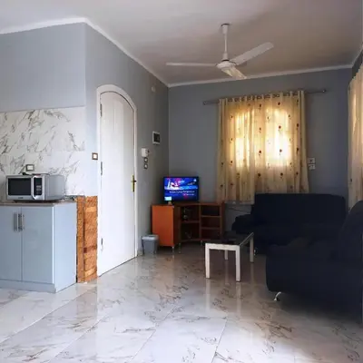 a living room with a couch and a tv at family villa private pool in Luxor