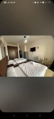 a bedroom with two beds and a television in it at فلورينزا الخمسين in Hurghada
