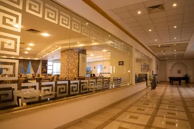 a dining room with a large window in a building at Dexon Roma All Inclusive Hotel in Hurghada