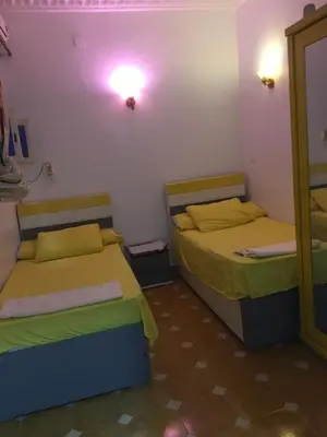 a room with two beds and a mirror at Gana kato in Aswan